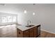 Kitchen island with a stainless steel sink and view of the adjacent living room and the windows at 288 Chesapeake Commons St # 149, Garner, NC 27529