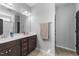 Double vanity bathroom with dark brown cabinets and a large mirror at 317 S Kramer Path, Clayton, NC 27527