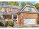 Traditional brick home with an attached two-car garage, an inviting front porch, and manicured landscaping at 3921 Robins Nest Ln, Wake Forest, NC 27587