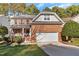 Charming brick two-story home featuring an attached two-car garage, a front porch, and a manicured lawn at 3921 Robins Nest Ln, Wake Forest, NC 27587