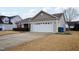 Tan house with red shutters, a white garage door, and a manicured lawn at 411 Joneshaven Dr, Fuquay Varina, NC 27526