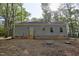 Back exterior with siding, a small deck with stairs, and a peaceful wooded backdrop at 512-A E Graham St, Mebane, NC 27302