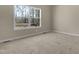 Bright bedroom features plush carpet, neutral walls, and a large window view at 512-A E Graham St, Mebane, NC 27302