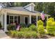 Gray house exterior with a covered porch, red cushions, and lush green landscaping at 619 Barbour St, Clayton, NC 27520