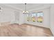 Bright dining room with hardwood floors, modern chandelier and large windows with neighborhood views at 66 Tennyson Dr, Garner, NC 27529