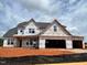 Image of an unfinished two-story home with visible wood framing and a multi-car garage at 66 Tennyson Dr, Garner, NC 27529