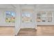 Bright foyer with beautiful hardwood floors, a white door, and three large windows at 66 Tennyson Dr, Garner, NC 27529