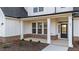 Front porch with white columns, brick accents and meticulous landscaping, showcasing home's curb appeal at 66 Tennyson Dr, Garner, NC 27529