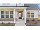 Inviting front porch featuring classic white columns, brick accents and a black front door at 66 Tennyson Dr, Garner, NC 27529
