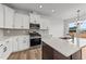 Stylish kitchen with white cabinets, stainless steel appliances, island, and modern lighting at 66 Tennyson Dr, Garner, NC 27529