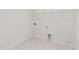 Bright laundry room with white walls, tile floors, shelving and a convenient pet door at 66 Tennyson Dr, Garner, NC 27529