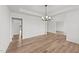 Open concept living room with hardwood floors, modern chandelier, and view of adjoining rooms at 66 Tennyson Dr, Garner, NC 27529