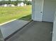 A covered patio with a concrete slab has views of the green backyard and new homes at 69 N Movado Trl, Kenly, NC 27542