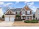 Two-story brick home with a two-car garage and landscaped front yard at 7572 Silver View Ln, Raleigh, NC 27613