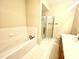 Well-lit bathroom featuring a soaking tub with tile surround and glass-enclosed shower at 814 Providence Glen Dr, Chapel Hill, NC 27514