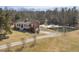 Aerial view of charming red house with pond and wooded area at 8437 Charlie Stovall Rd, Oxford, NC 27565