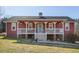 Red house exterior with wrap around porch and pond view at 8437 Charlie Stovall Rd, Oxford, NC 27565