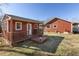 Small red shed with a deck and railing in the backyard at 8437 Charlie Stovall Rd, Oxford, NC 27565