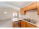 Kitchen with wood cabinets, stainless steel dishwasher, and view of living area at 9104 Colony Village Ln, Raleigh, NC 27617