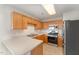 Galley kitchen with wood cabinets, stainless steel appliances, and tile floor at 9104 Colony Village Ln, Raleigh, NC 27617
