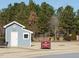 Small blue community shed with a grassy area, trees and sign at 116 Telluride Trl, Garner, NC 27529