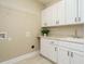 Laundry room with white cabinets and a built-in sink at 116 Telluride Trl, Garner, NC 27529