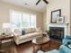 Living room with large windows, fireplace, and comfy seating at 116 Telluride Trl, Garner, NC 27529