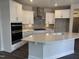 Modern kitchen with island, stainless steel appliances, and white cabinets at 1315 Richfield Oaks Dr, Homesite 3, Fuquay Varina, NC 27526