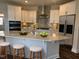 Modern kitchen with white cabinets, stainless steel appliances, and an island at 1315 Richfield Oaks Dr, Homesite 3, Fuquay Varina, NC 27526