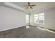 Bright bedroom featuring plush carpet, a tray ceiling with fan, and natural light from multiple windows at 134 Oban Dr, Homesite 133, Sanford, NC 27330