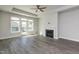 Bright living room featuring a fireplace, ceiling fan, and access to an outdoor patio through glass doors at 134 Oban Dr, Homesite 133, Sanford, NC 27330
