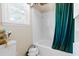 Clean bathroom with a white tiled bathtub and green curtain is brightened by a natural light-filled window at 1741 W Blackman Rd, Dunn, NC 28334
