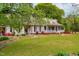 Inviting home with a cozy covered porch and beautiful, lush landscaping at 1741 W Blackman Rd, Dunn, NC 28334