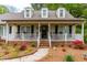 Inviting front porch features rocking chairs, decorative wreath, and manicured landscaping at 1741 W Blackman Rd, Dunn, NC 28334