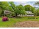 Spacious front yard featuring lush landscaping, mature trees, and a covered carport at 1741 W Blackman Rd, Dunn, NC 28334