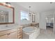 Bright bathroom features double vanities, soaking tub with tile surround, and decorative lighting at 189 Sunrise Ridge Dr, Willow Springs, NC 27592