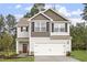 Two-story house with neutral siding, a double garage, and landscaping at 207 Shelfit Trl, Oxford, NC 27565