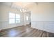 Dining room showcasing wainscoting, wood floors, natural light, and an open doorway at 223 Johnson Ridge Way, Four Oaks, NC 27524