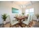 Bright dining room with wainscoting, wood table, chandelier, and large window at 223 Johnson Ridge Way, Four Oaks, NC 27524