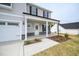 Welcoming front porch with stone accents and professionally landscaped flower beds at 223 Johnson Ridge Way, Four Oaks, NC 27524