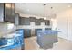 Bright kitchen featuring gray cabinets, an island, subway tile backsplash, and stainless steel appliances at 223 Johnson Ridge Way, Four Oaks, NC 27524