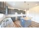 Bright kitchen with gray cabinets, white subway tile backsplash, granite countertops and stainless steel sink at 223 Johnson Ridge Way, Four Oaks, NC 27524