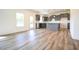 Open kitchen with gray cabinets, white subway tile, island, and wood floors at 223 Johnson Ridge Way, Four Oaks, NC 27524