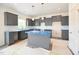 A new kitchen with gray cabinets, an island, white subway tile, and stainless steel sink at 223 Johnson Ridge Way, Four Oaks, NC 27524