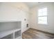 Well-lit laundry room with shelving and laminate flooring at 223 Johnson Ridge Way, Four Oaks, NC 27524