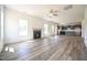 Open living area showcasing fireplace, natural light, and wood floors leading to kitchen at 223 Johnson Ridge Way, Four Oaks, NC 27524