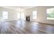 Spacious living room with fireplace, ample windows, wood floors, and ceiling fan at 223 Johnson Ridge Way, Four Oaks, NC 27524