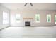 Bright living room with fireplace, complemented by ample windows and a ceiling fan at 223 Johnson Ridge Way, Four Oaks, NC 27524