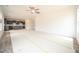 Open-concept living area flows into kitchen with abundant natural light and ceiling fan at 223 Johnson Ridge Way, Four Oaks, NC 27524