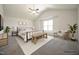 Staged main bedroom featuring vaulted ceiling, ceiling fan, large window, and neutral color palette at 223 Johnson Ridge Way, Four Oaks, NC 27524